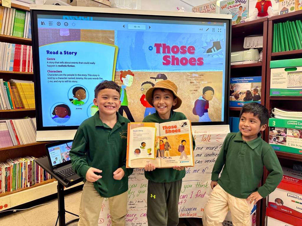 Aharon, Simon, and James demonstrate the book Those Shoes