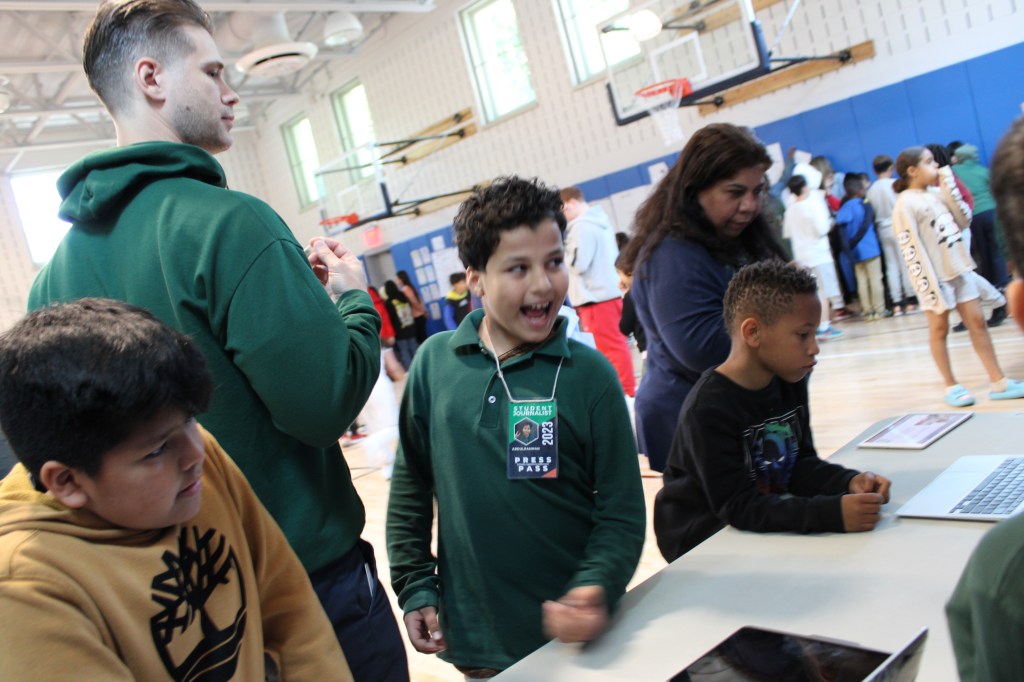 Students are standing in front of one of the exposition desks.